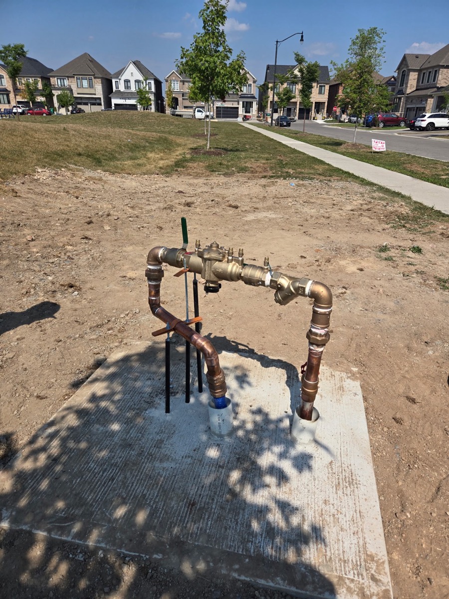 Copper backflow preventer assembly on a water service outside a new building