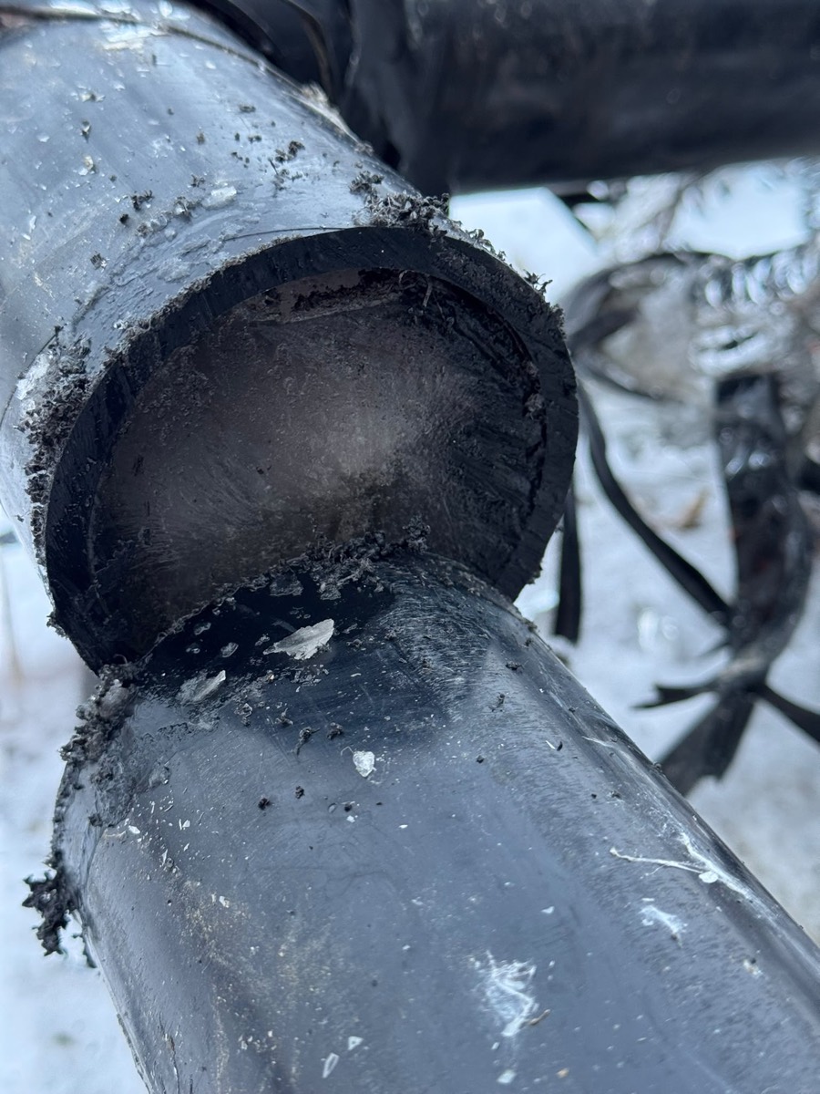 Cut end of a cast iron kitchen drain line showing the buildup inside