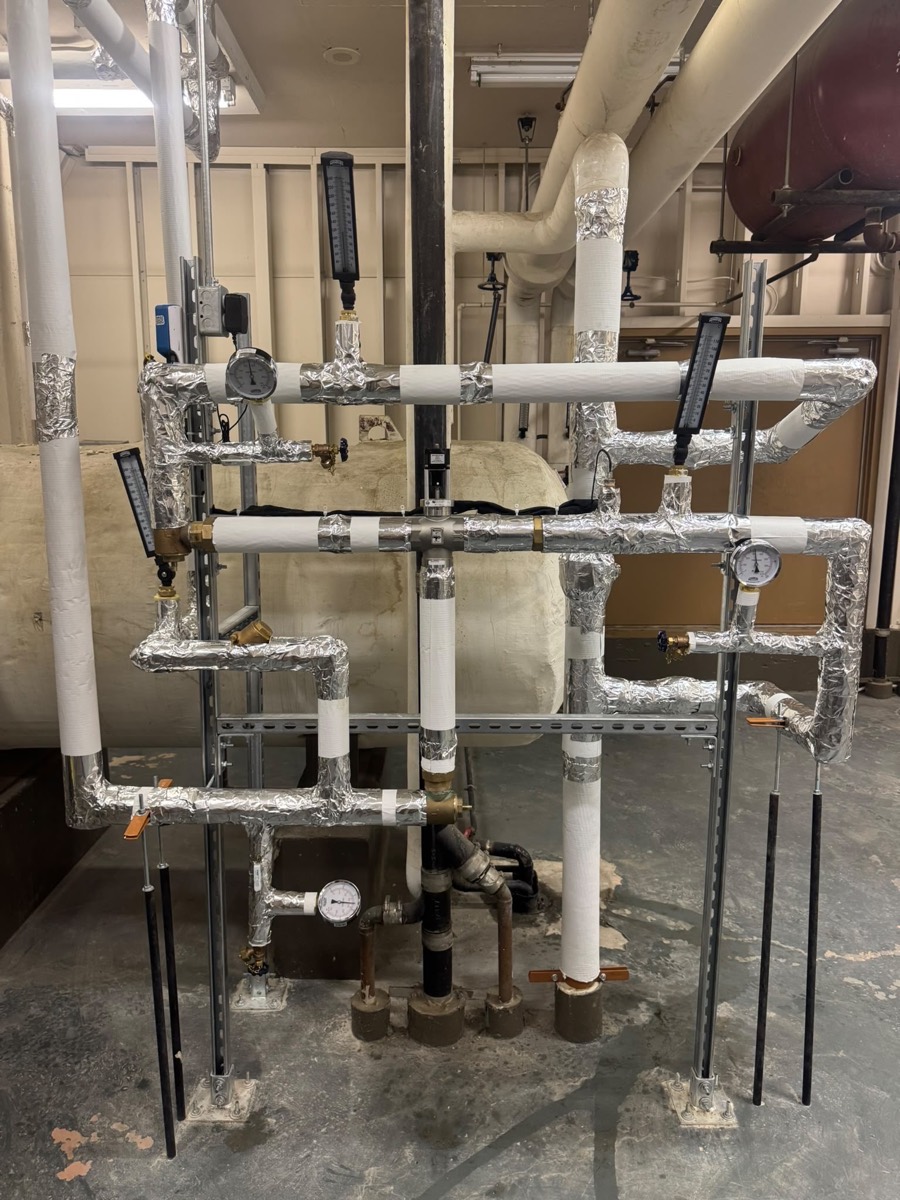 Commercial mechanical room with insulated piping, pumps and valves