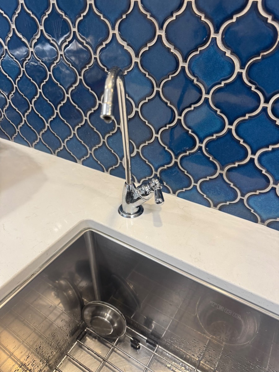 Dedicated drinking-water faucet beside a stainless kitchen sink