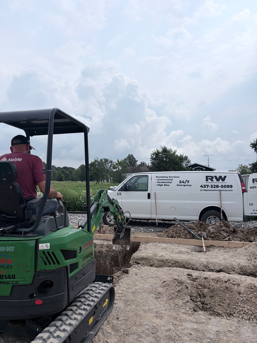 Technician in a mini excavator with a Ridgewood Mechanical van behind