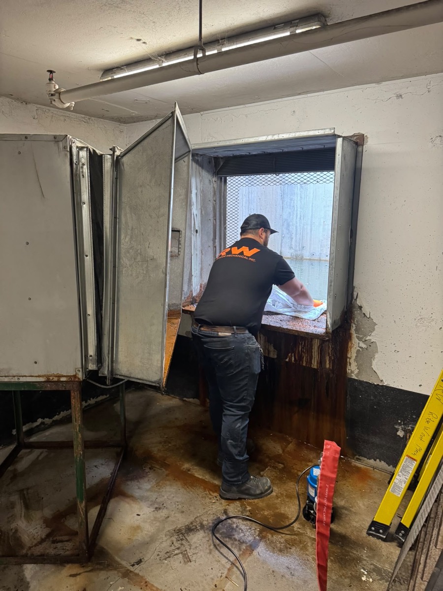 Technician working at a mechanical room equipment cabinet