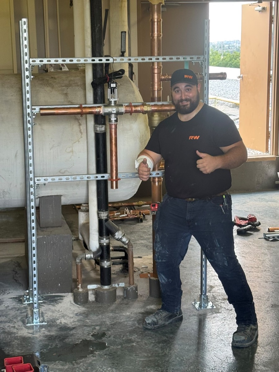 Technician beside a newly installed copper riser assembly
