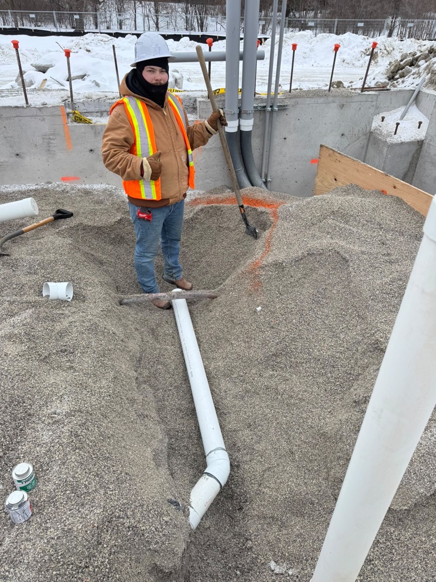 Technician in high-visibility gear on a winter excavation