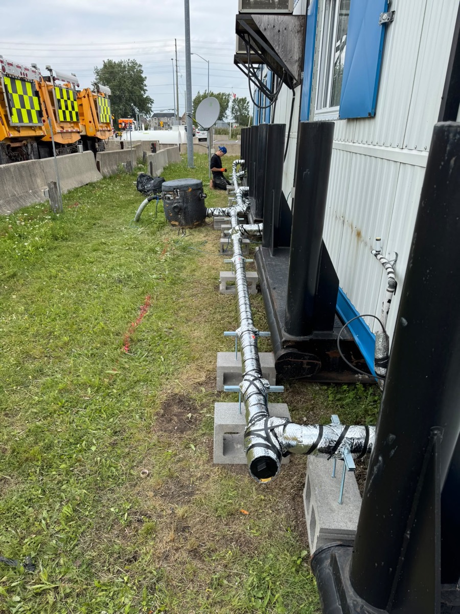 Temporary water piping running along site trailers