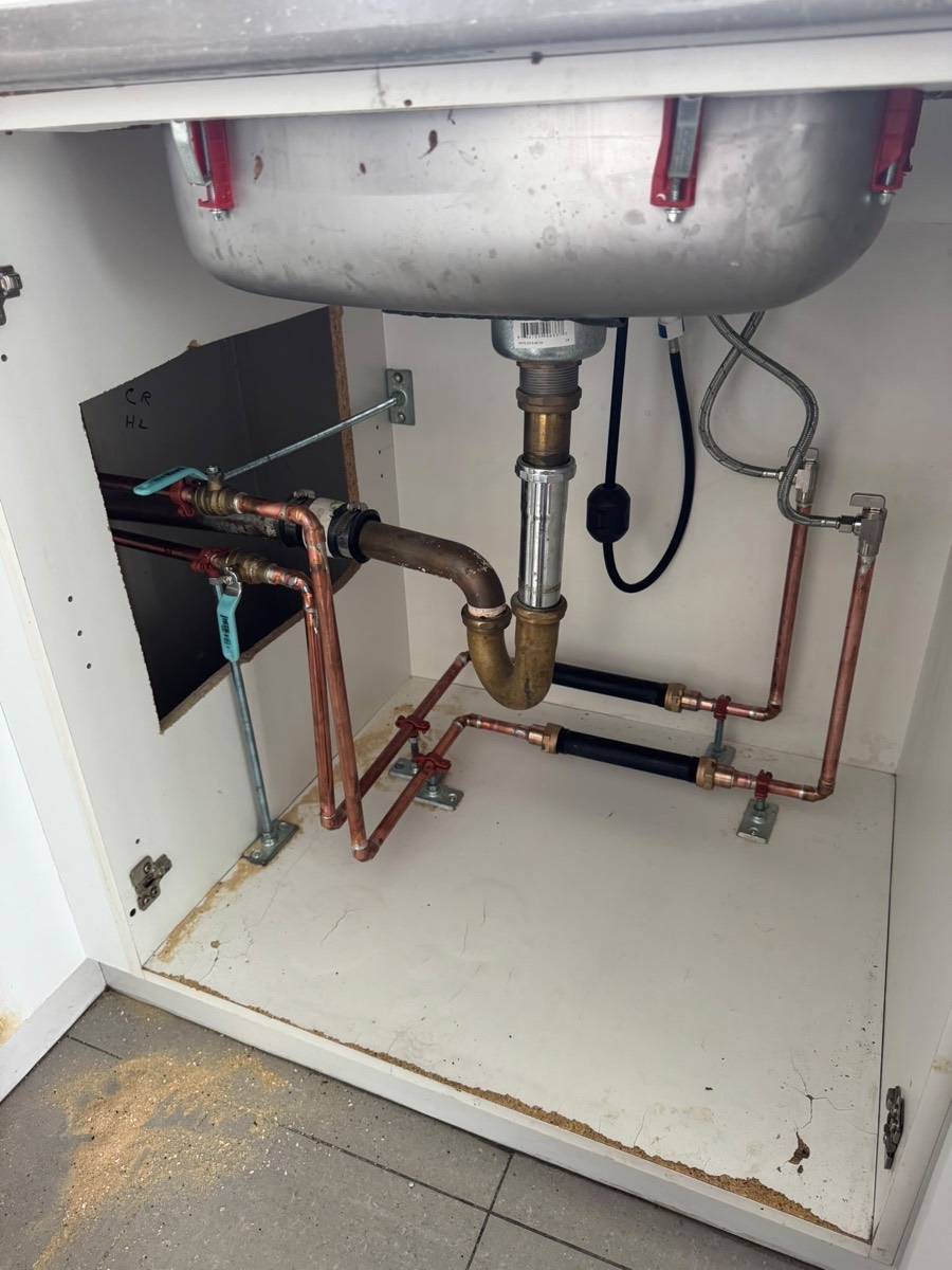 Clean copper supply and drain work under a kitchen sink