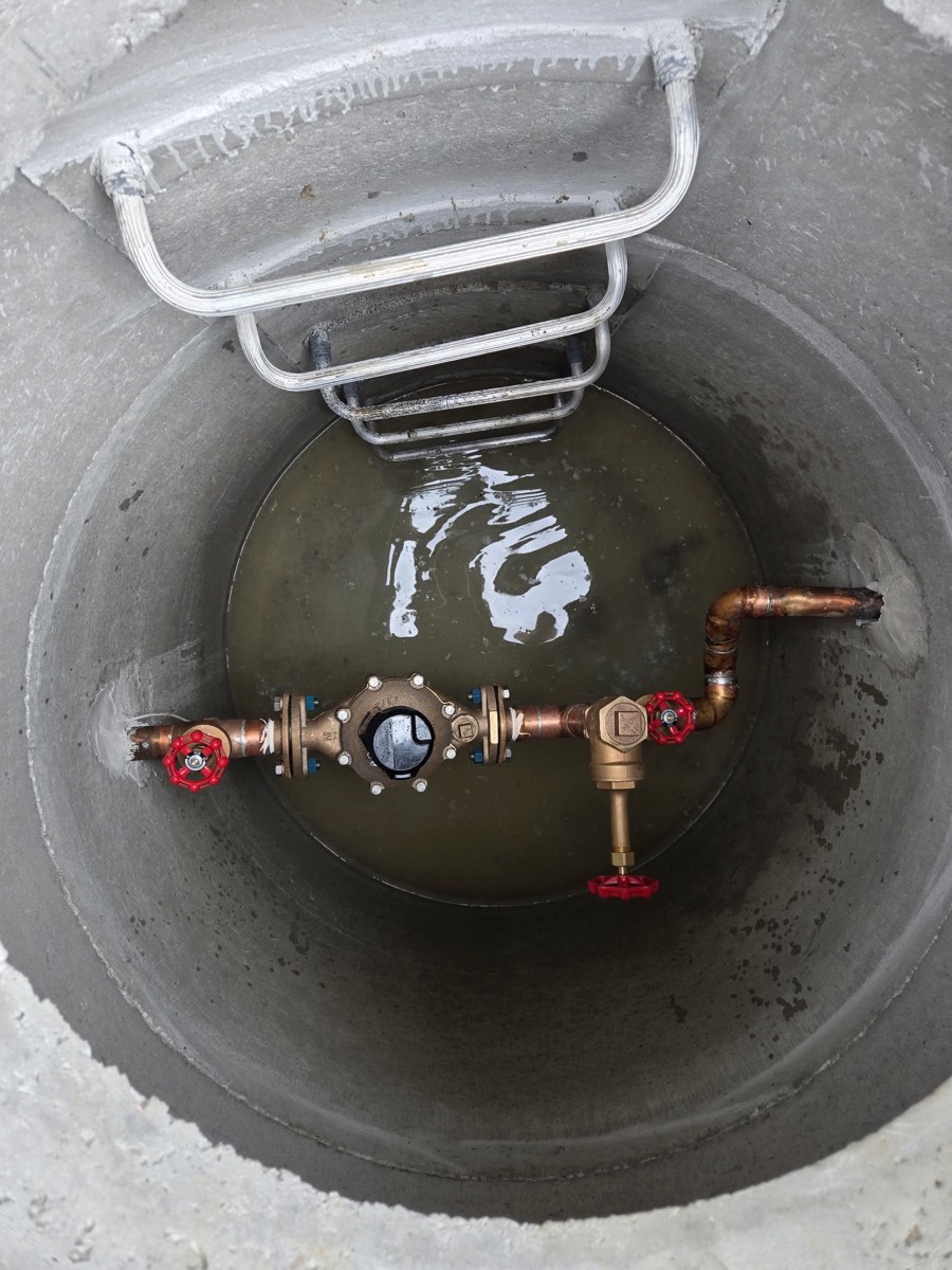 Valve assembly inside a concrete water service chamber